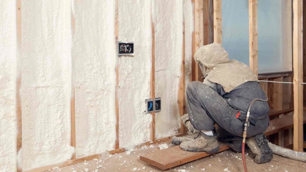A man is working on fireproofing a room.